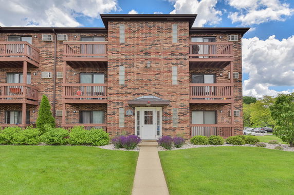 Front view of a brick apartment building with balconies.