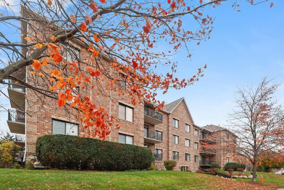 Front view of a multi-story brick apartment building with balconies.