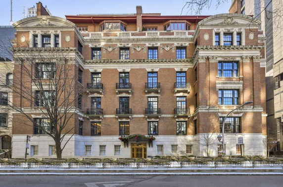 Front view of a multi-story brick building with decorative stonework and balconies.