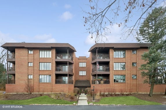 Front view of a multi-story brick apartment building with balconies.