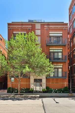 Front view of a multi-story brick building with balconies.