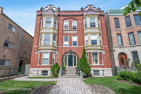 Front view of a three-story brick building with decorative features.
