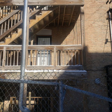 Back view of a brick building with wooden staircases.