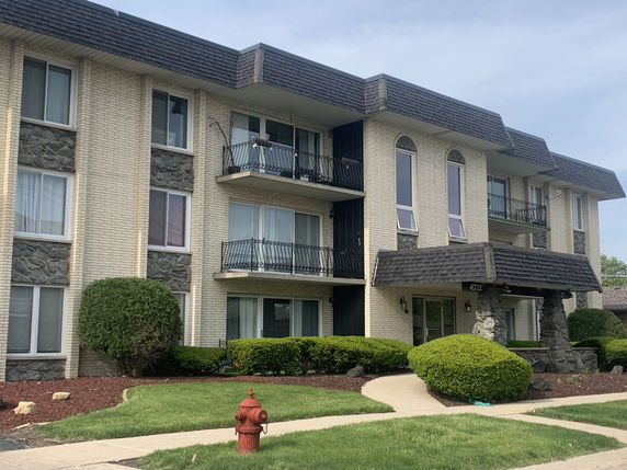 Front view of a multi-story apartment building with balconies.