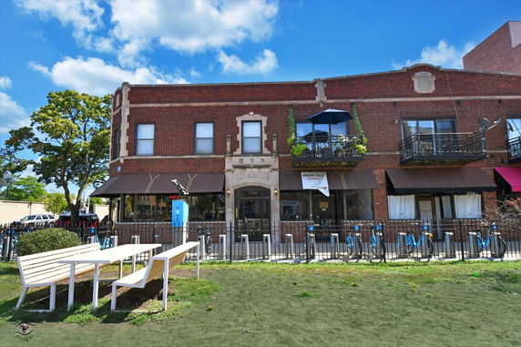 Front view of a two-story brick building with awnings and balconies.