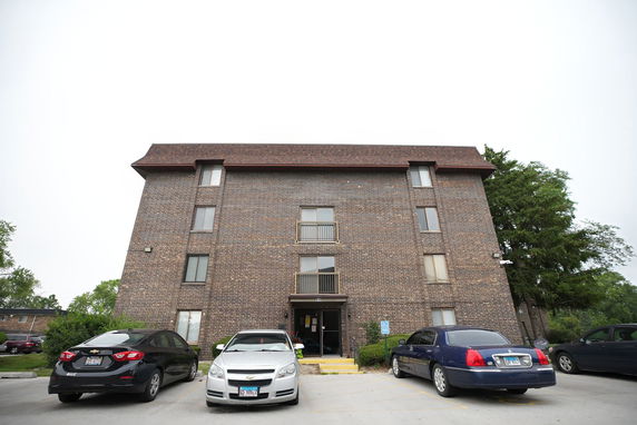 Front view of a multi-story brick building with a flat roof and multiple windows.
