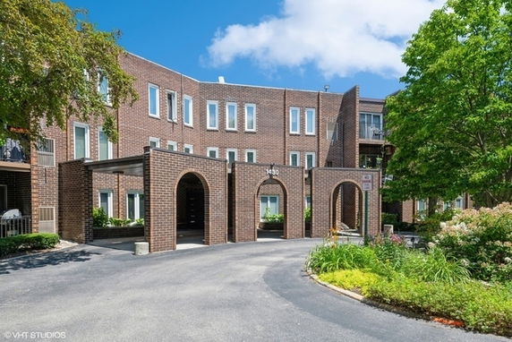 Front view of a multi-story brick building with arched entryways.