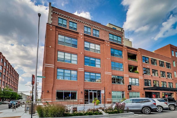Front view of a multi-story brick building with large windows.