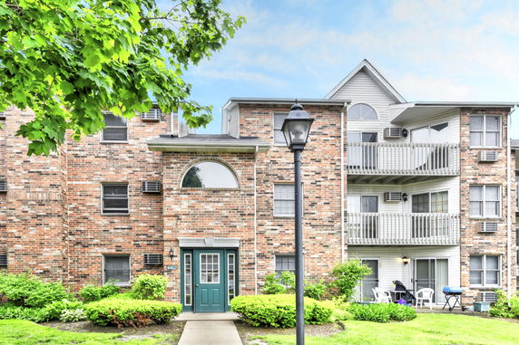 Front view of a multi-story brick apartment building with balconies.