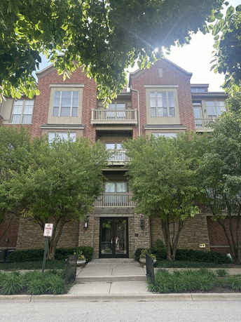 Front view of a multi-story brick building with balconies and large windows.
