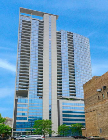 Front view of a tall modern high-rise building with glass facade.