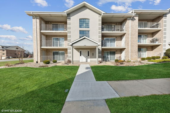 Front view of a multi-story residential building with multiple balconies.