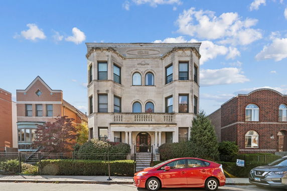 Front view of a three-story residential building with bay windows.
