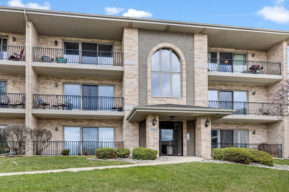Front view of a multi-story apartment building with balconies.