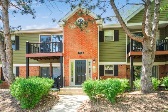 Front view of a two-story house with brick and green siding.