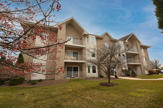 Front view of a multi-story apartment building with balconies.