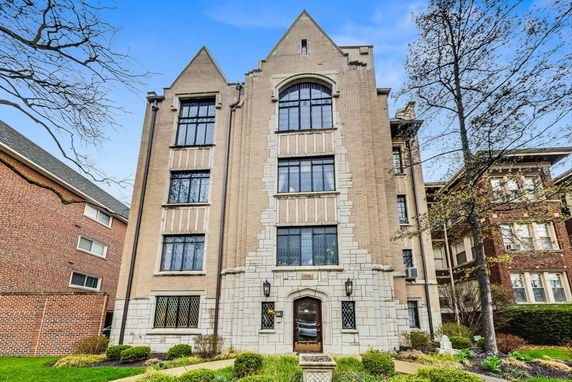 Front view of a multi-story brick apartment building with decorative elements.