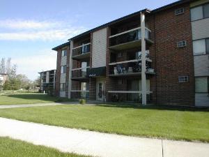 Front view of a multi-story apartment building with balconies.