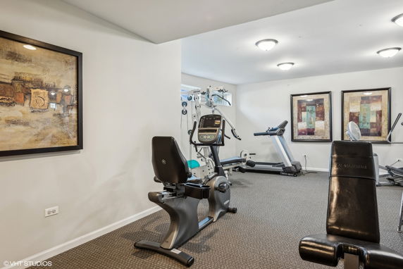 Indoor gym area with exercise equipment and decorative wall art.