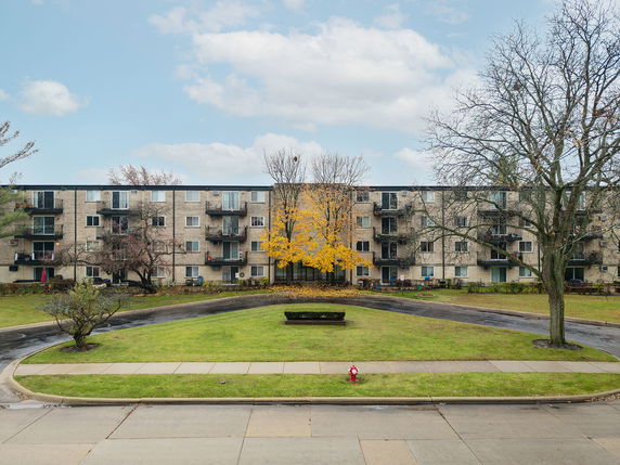 Front view of a multi-story apartment building with balconies.