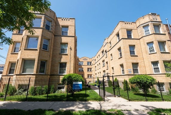 Front view of a brick apartment building with multiple stories.