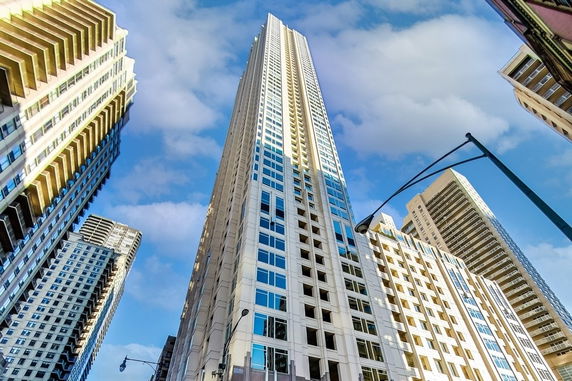 Tall skyscraper with modern facade against a blue sky