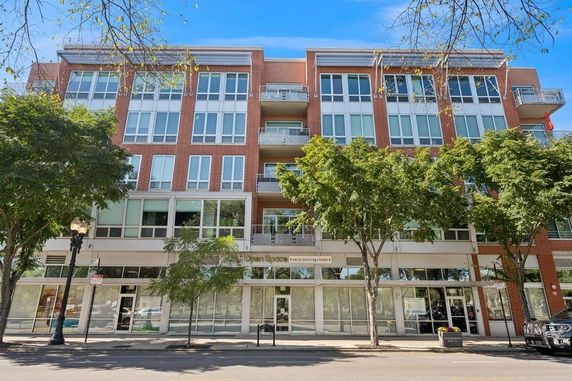 Front view of a multi-story building with large windows and balconies.
