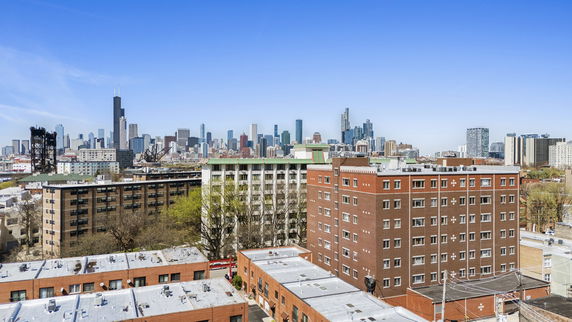 Panoramic cityscape view featuring multiple buildings with a skyline in the background.