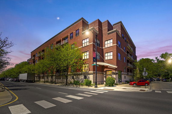 Front view of a multi-story brick building at a street corner