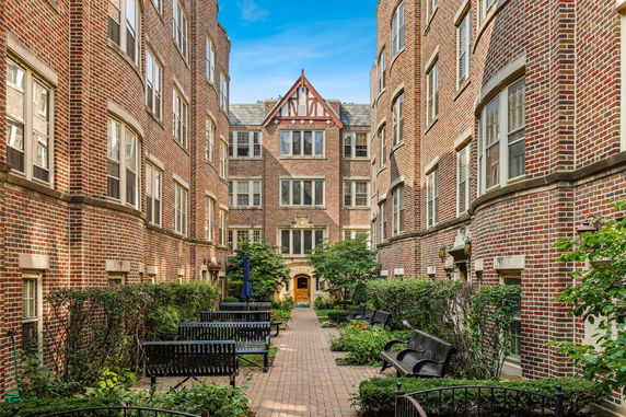 Front view of a multi-story brick building with multiple windows.