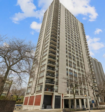 Front view of a tall residential building with multiple floors and balconies.