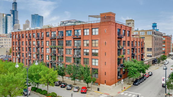 Front view of a mid-rise brick apartment building with multiple balconies.