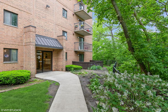 Front view of a brick apartment building with balconies.