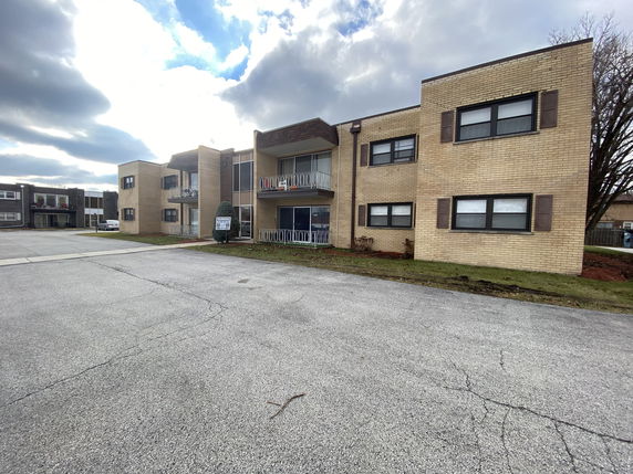 Front view of a two-story apartment complex with balconies.