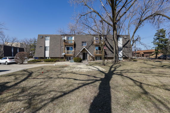Front view of a three-story residential building with balconies.