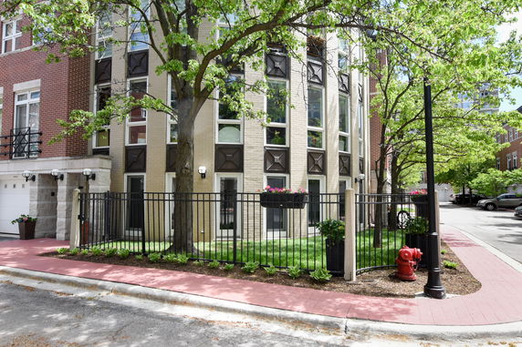 Front view of a multi-story brick building with large windows.