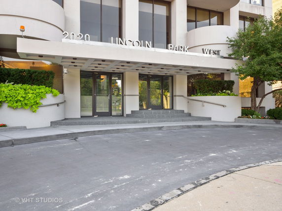Front view of a building entrance with glass doors and a canopy.