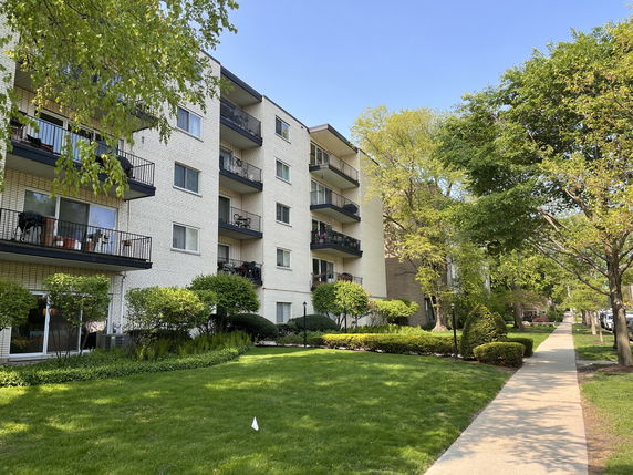 Front view of a multi-story apartment building with balconies.
