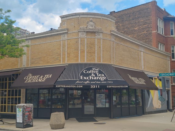 Front view of a coffee and tea shop with brick facade and awning.