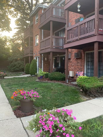 Front view of a multi-story brick apartment building with balconies.