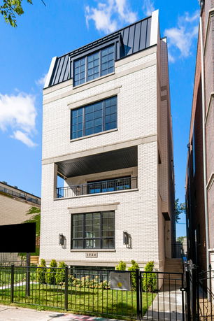 Front view of a multi-story brick building with large windows.