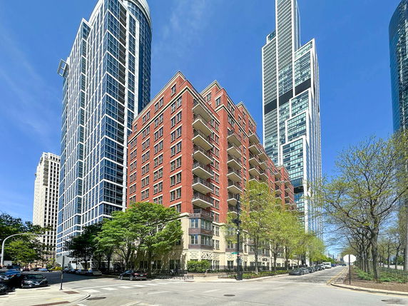 Front view of a multi-story building with red brick exterior and balconies.