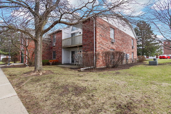 Front view of a two-story brick building with a small balcony.