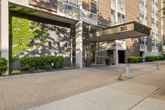 Front view of a multi-story building with brick facade and glass entrance.