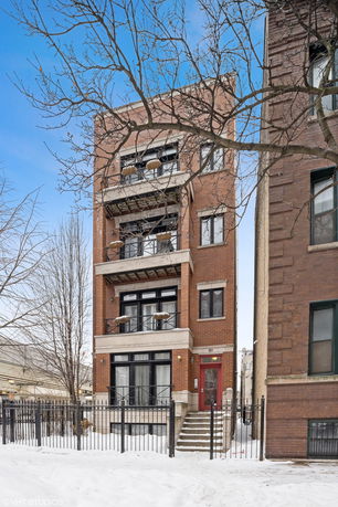 Front view of a multi-story brick building with balconies.