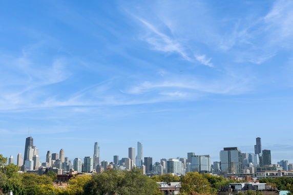 Panoramic view of a city skyline with tall buildings under a clear blue sky.