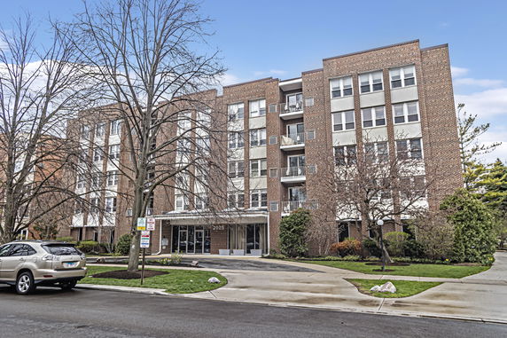 Front view of a multi-story brick apartment building with balconies.