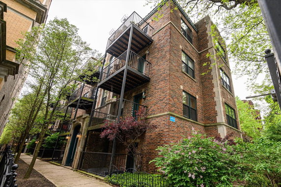Front view of a multi-story brick building with balconies.