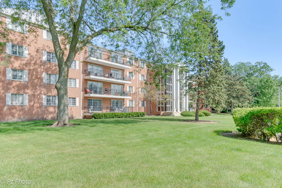 Front view of a multi-story apartment building with balconies.
