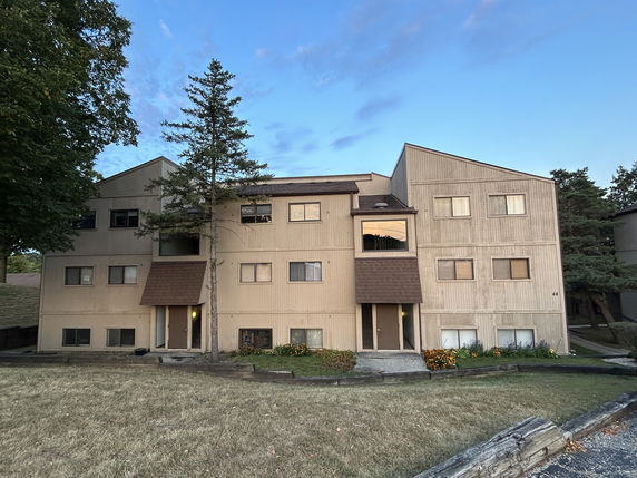 Front view of a multi-story residential building with several windows and entrances.